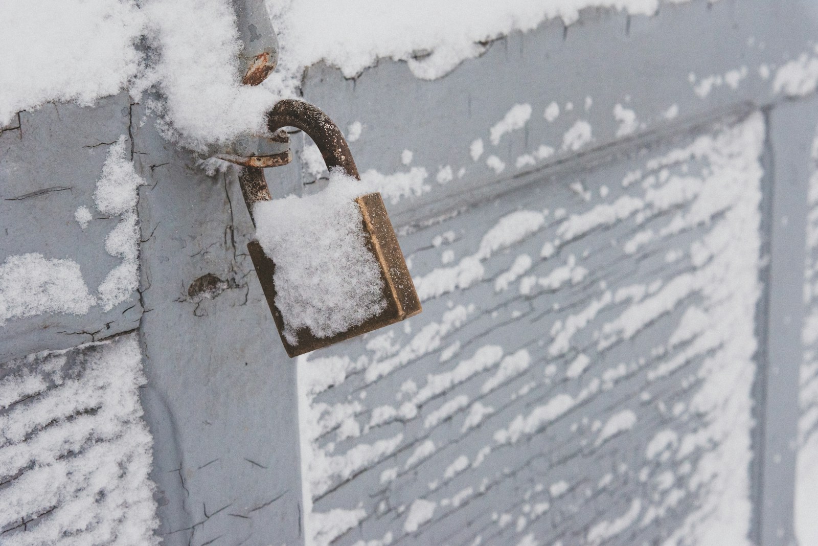 a padlock on the side of a building covered in snow