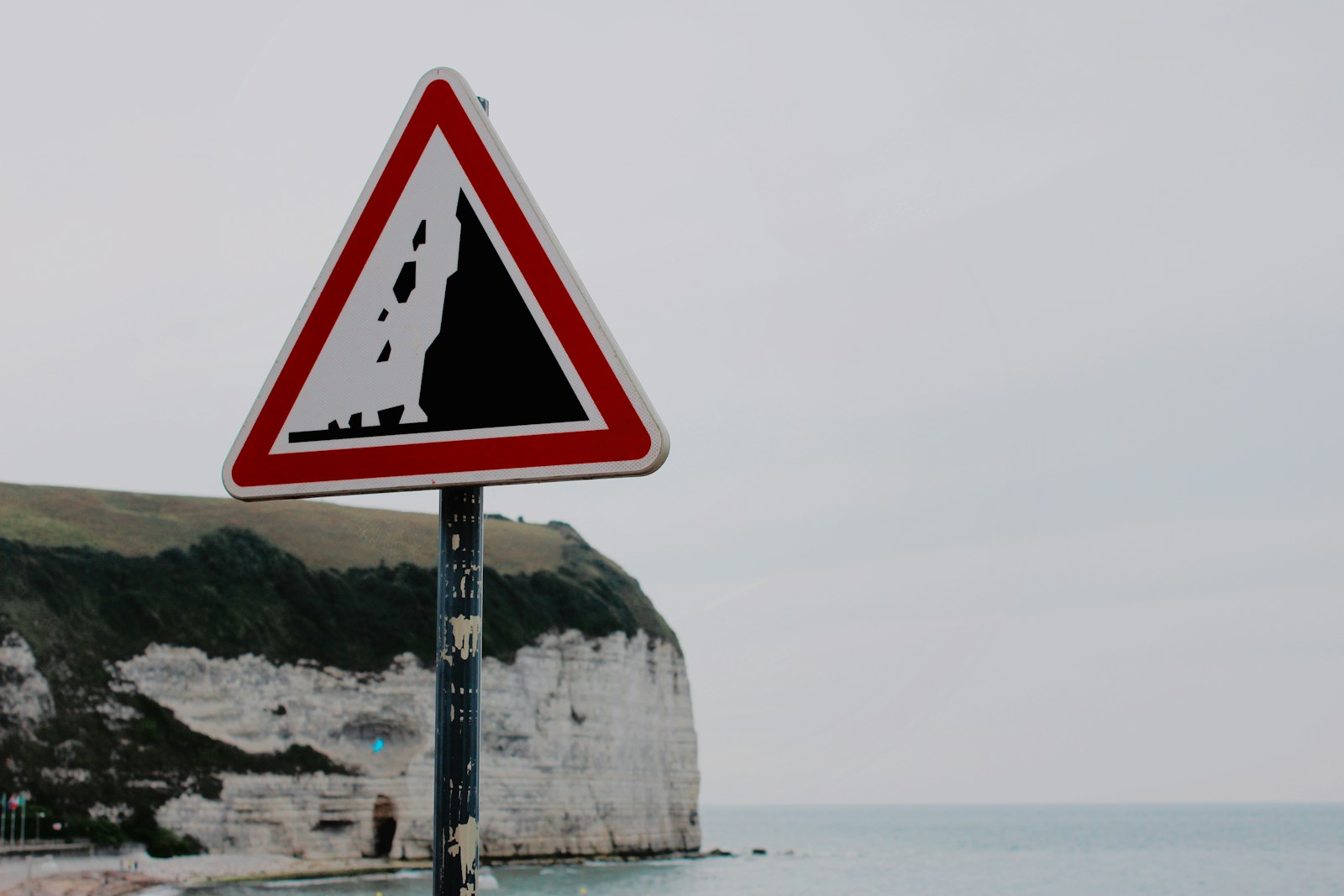 black and red signage near body of water at daytime