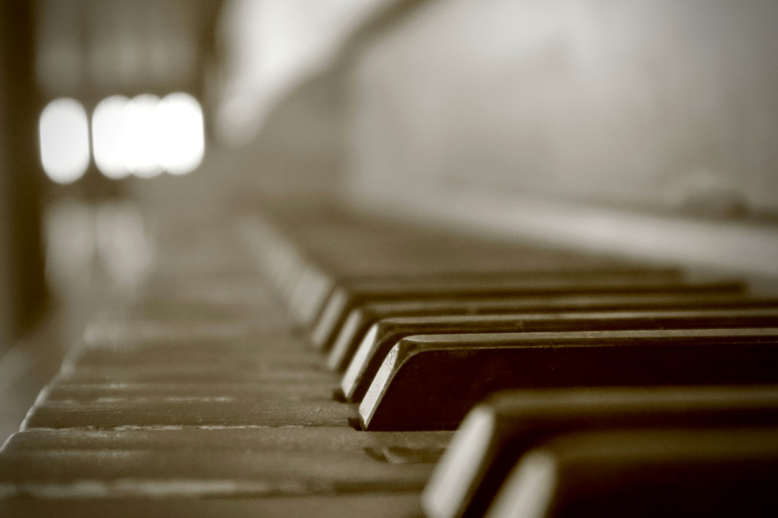 Worn piano keys with a soft, out-of-focus background