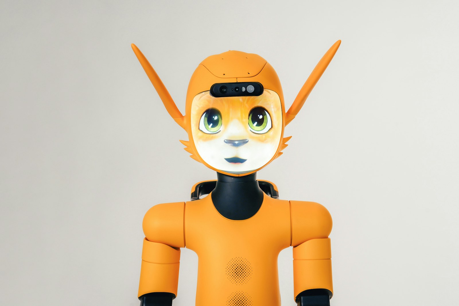 An orange humanoid robot with a digital cat face and pointed ears