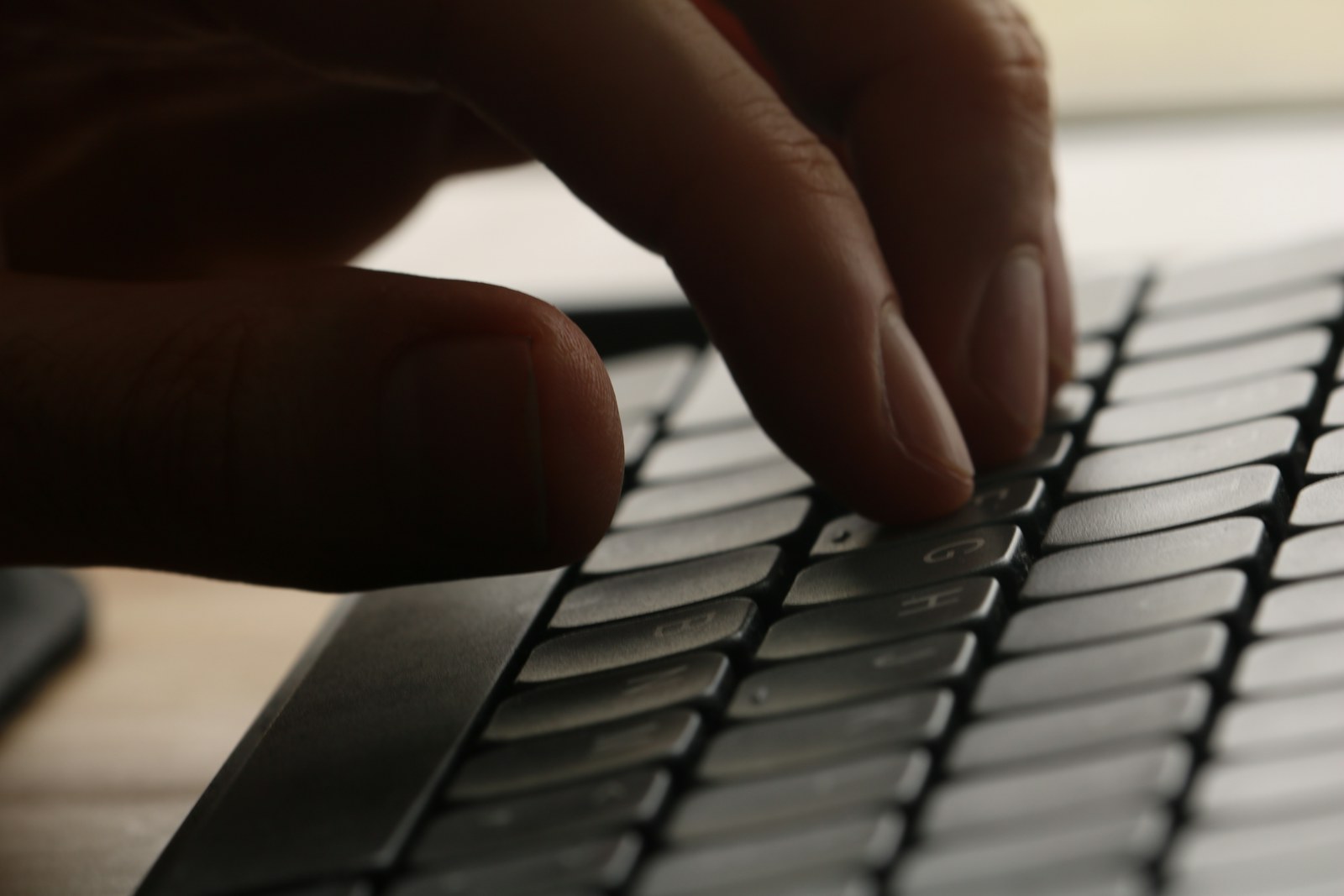 Close-up of a hand typing on a computer keyboard