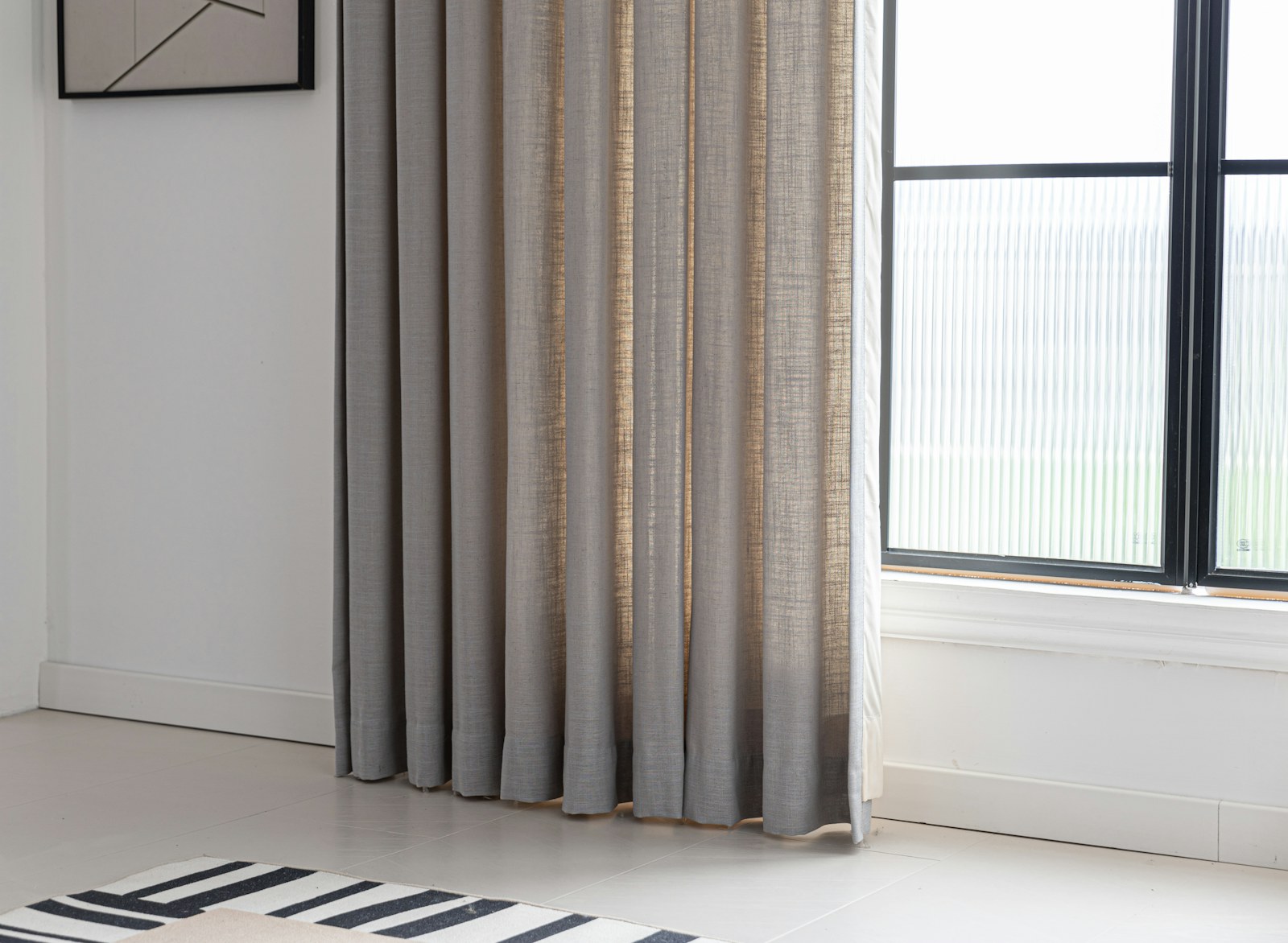 Curtains frame a window in a bright room