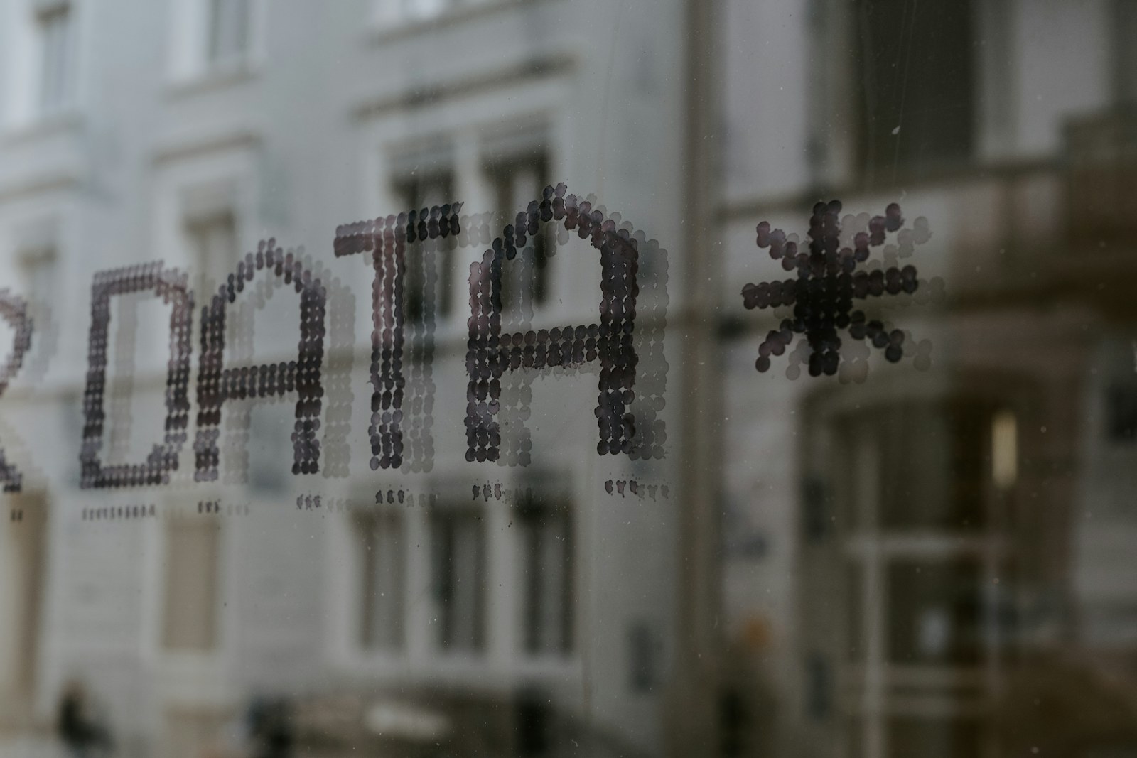 The word DATA and a star symbol stenciled in dark dots on glass