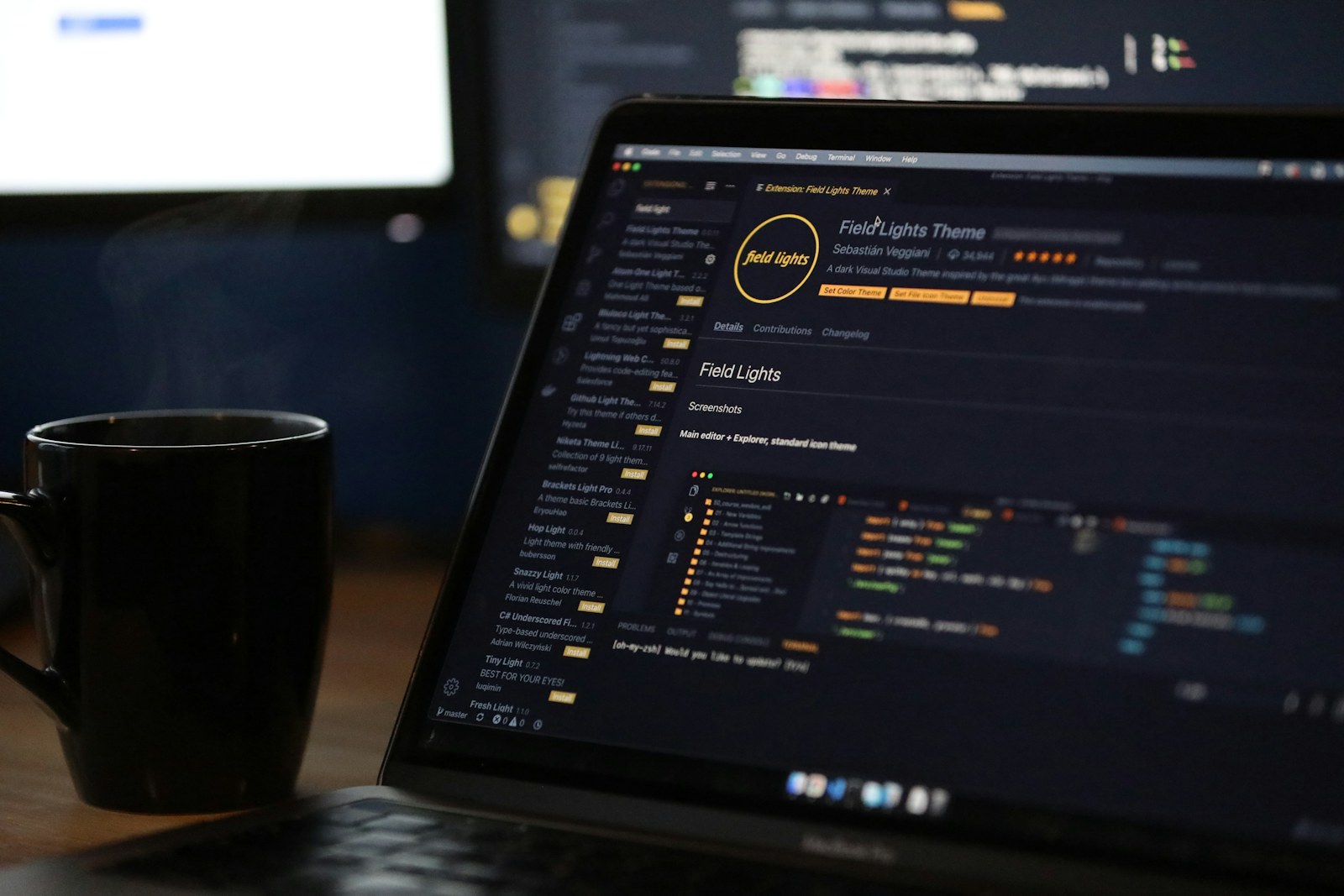 A laptop screen displaying code and a steaming mug on a desk