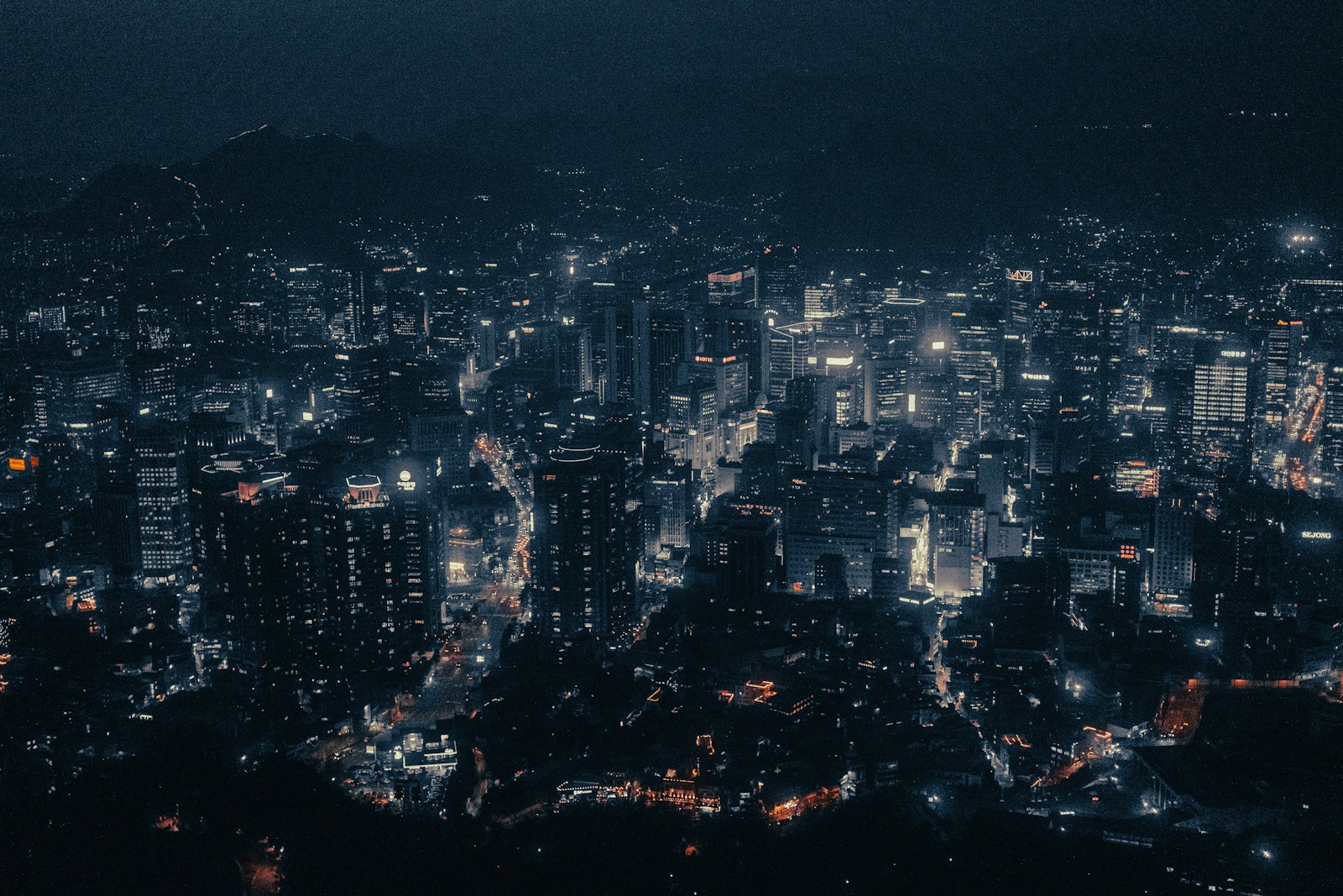 A view of a city at night from the top of a hill