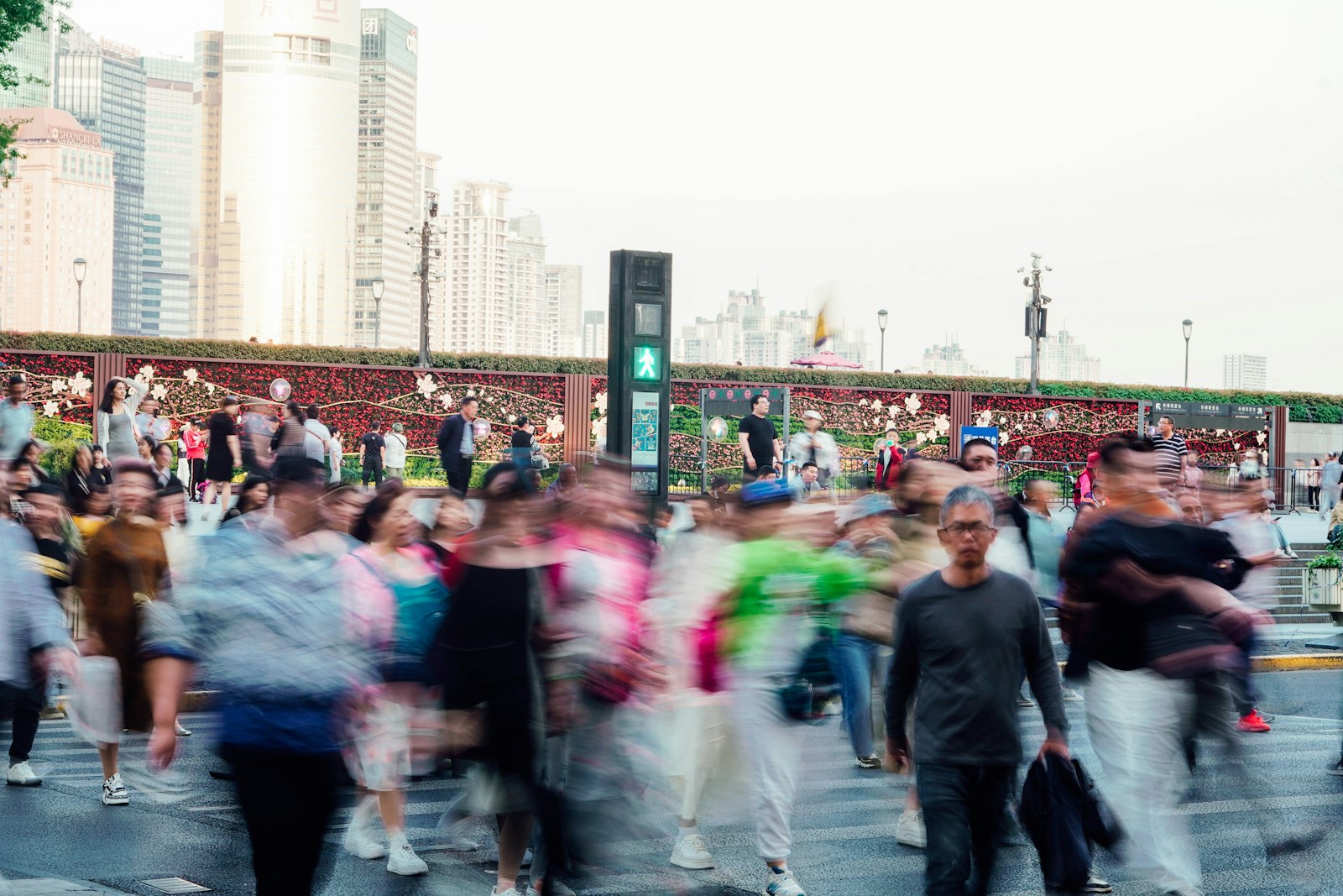 Blurred crowd of people walking across a city street