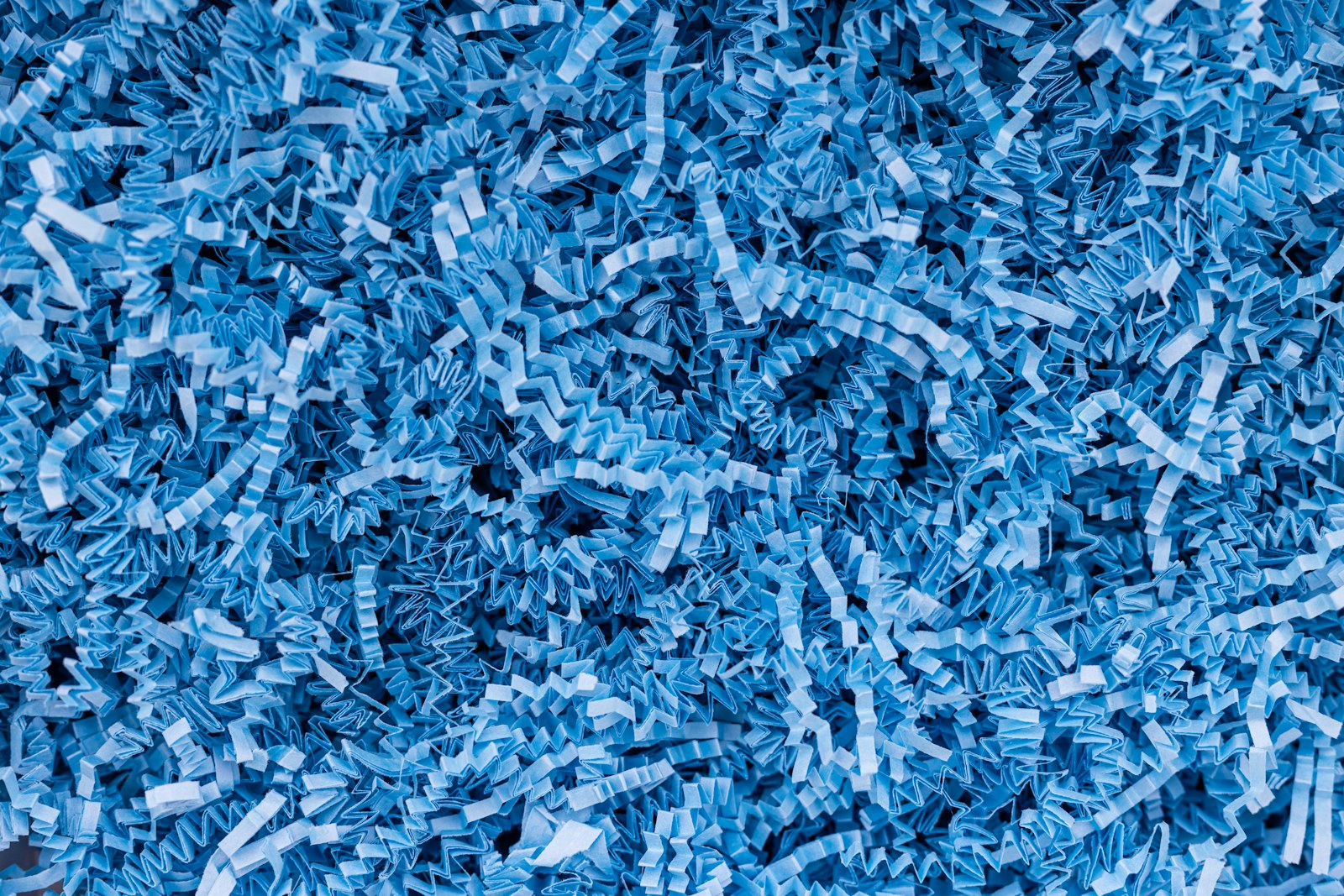 A pile of blue shredded paper sitting on top of a table