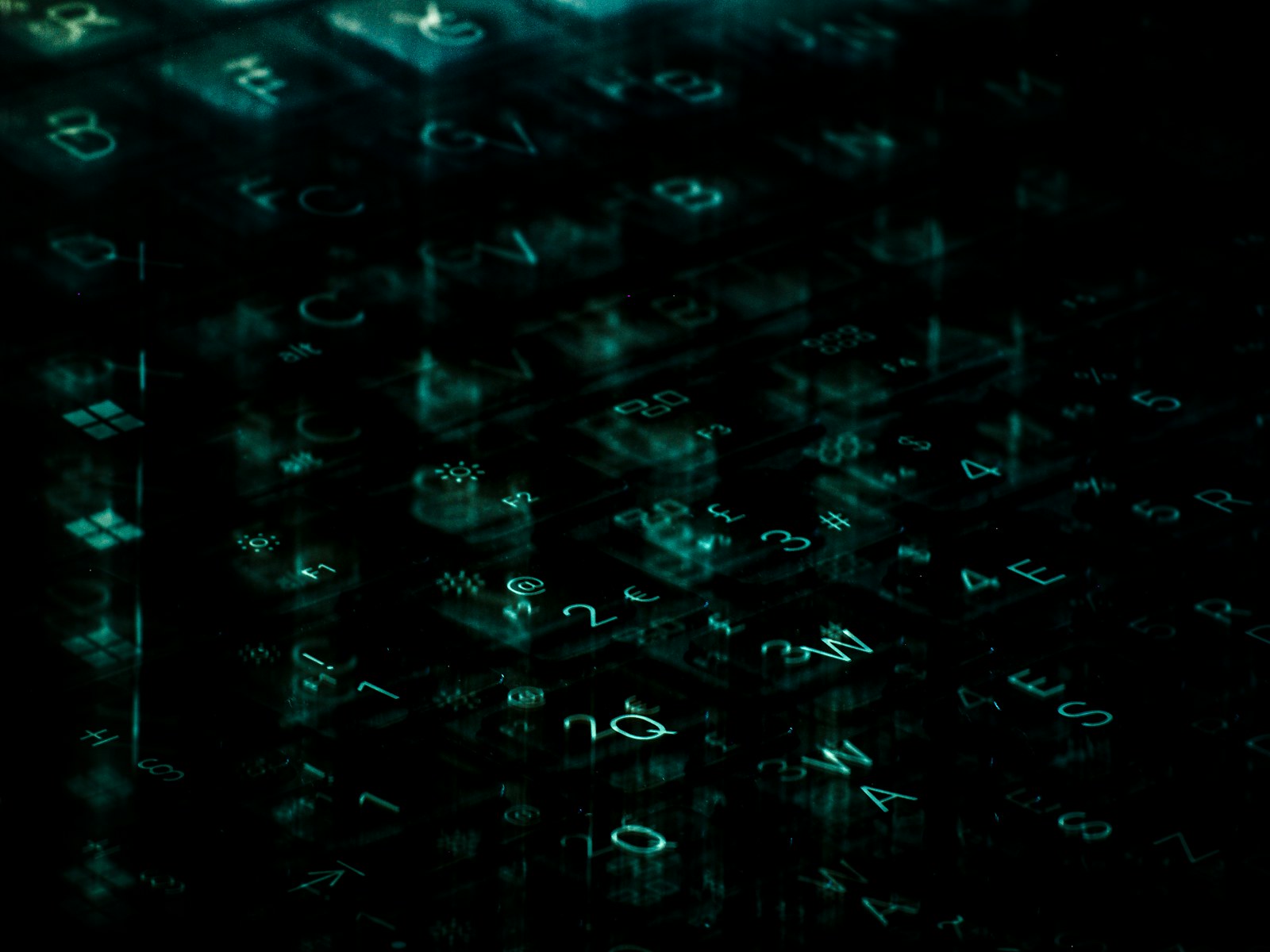 A computer keyboard with a green light shining on it