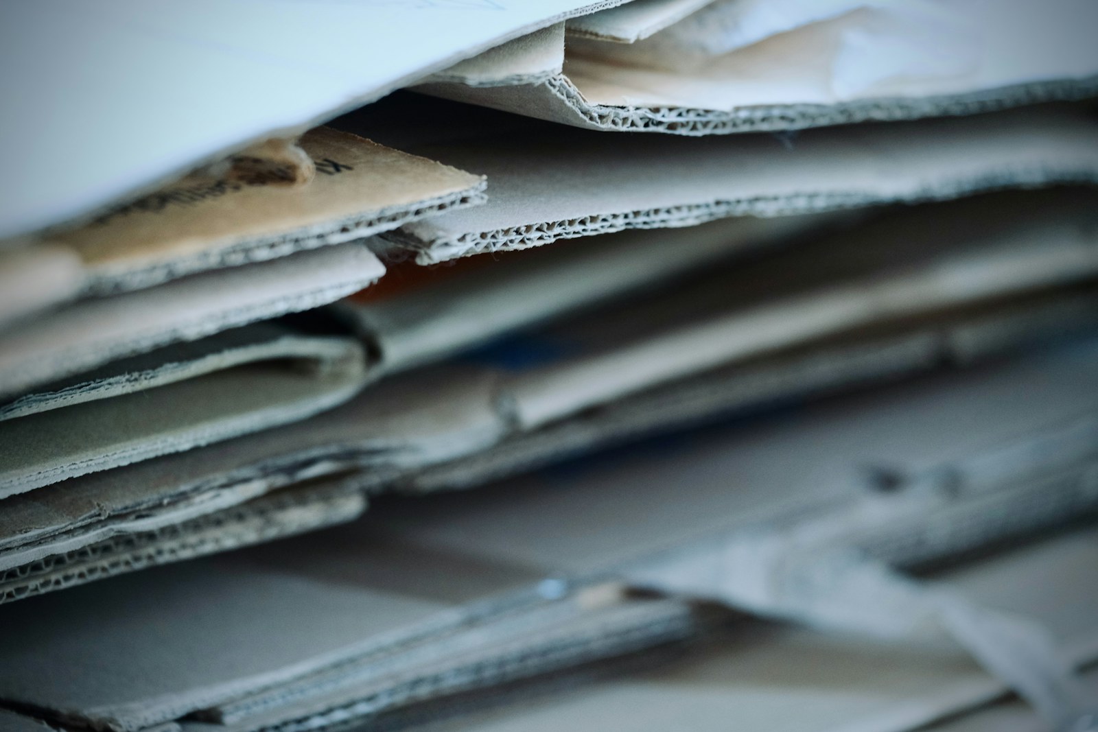 A stack of layered corrugated cardboard sheets with rough edges