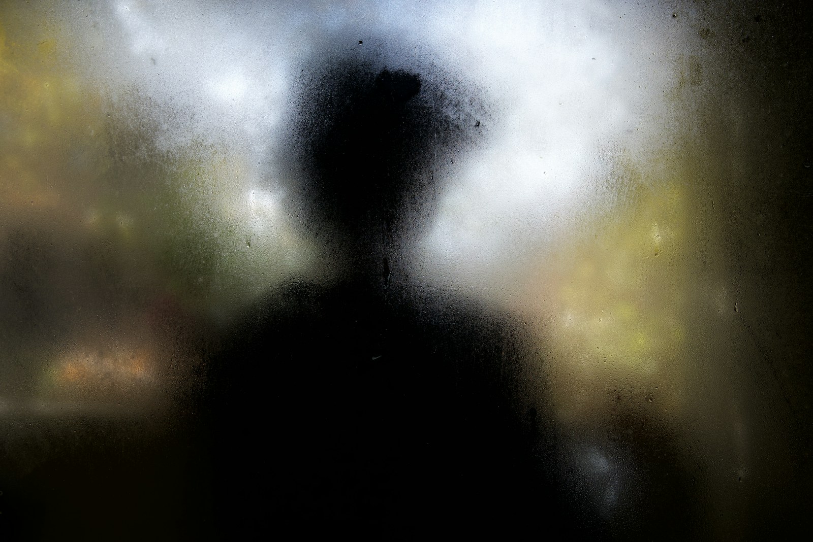 A blurry image of a person standing in front of a window