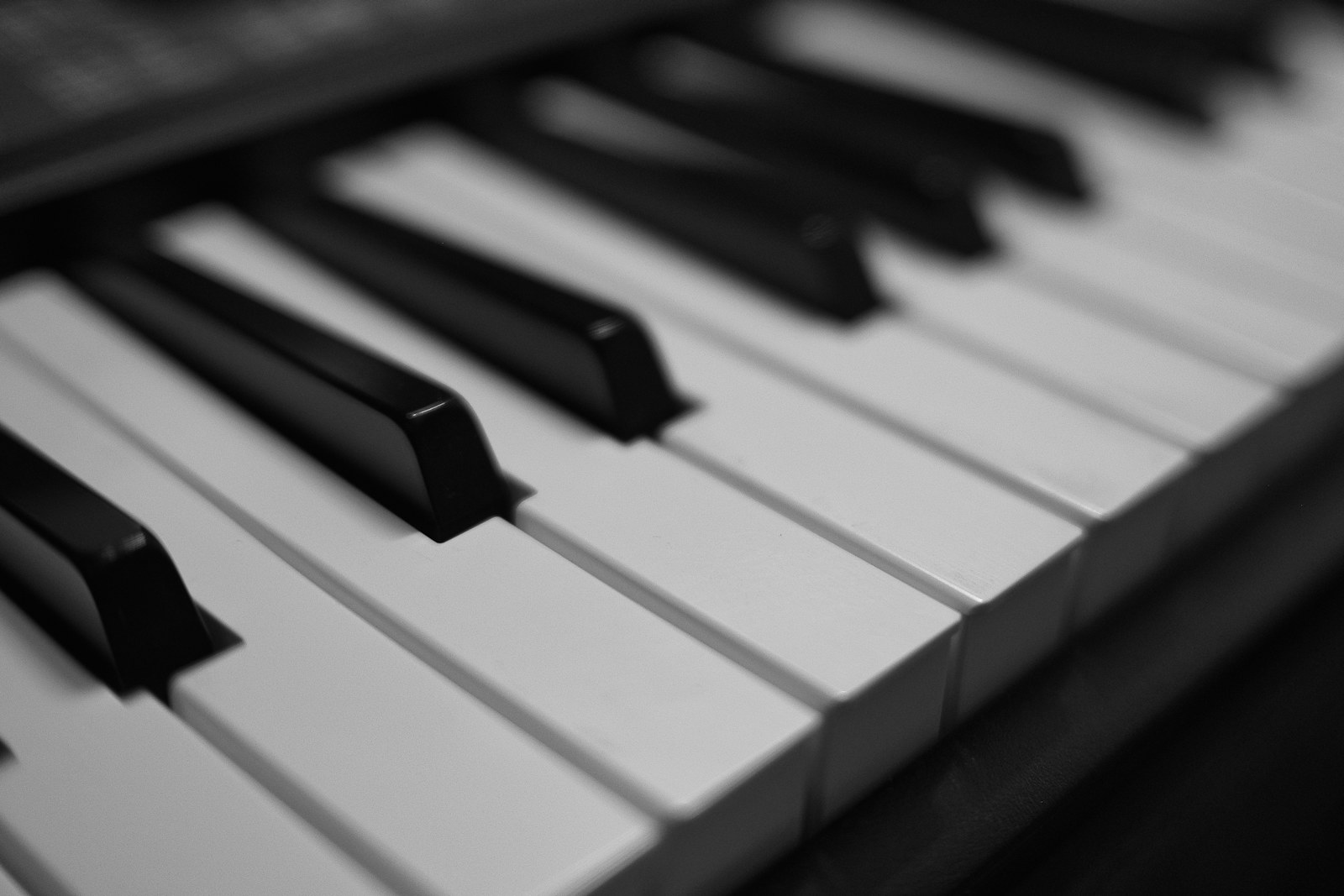 A close-up of black and white piano keys in a shallow depth of field