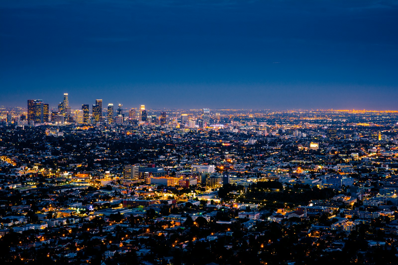 The illuminated skyline of Los Angeles at night under a deep blue sky
