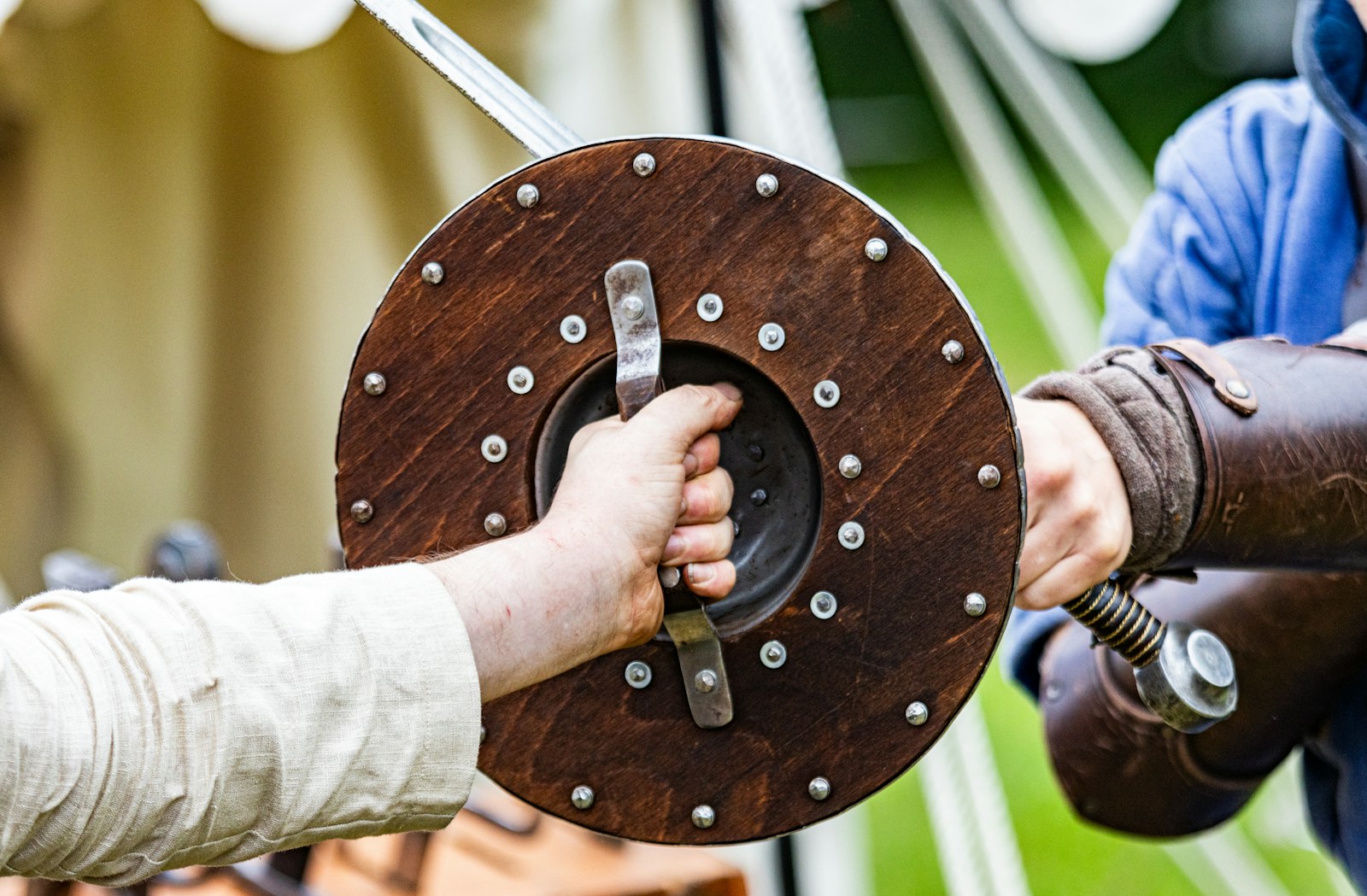 a person holding a sword with another person's hand